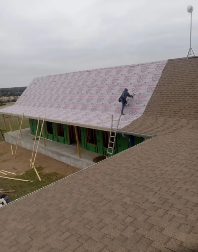 Worker preparing underlayment for a metal roof installation in Bay Harbor Islands